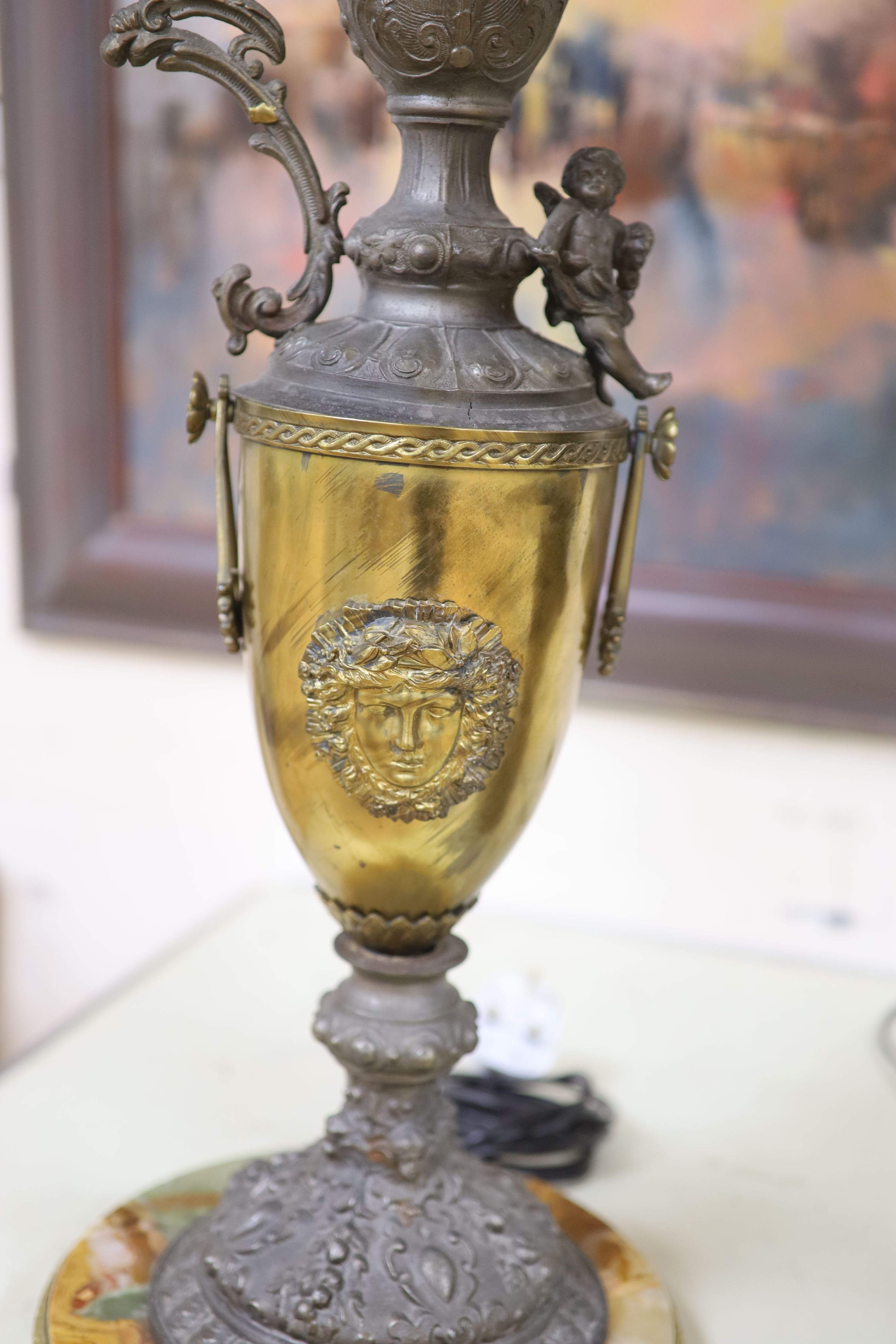 A Florentine style brass, spelter and onyx ewer shaped table lamp and a bronzed spelter figural table lamp with glass shades